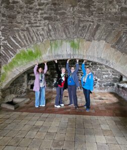 Travel advisor Pam Swafford and travel companions inside the kitchen archway at Doune Castle, Castle Leoch in Outlander